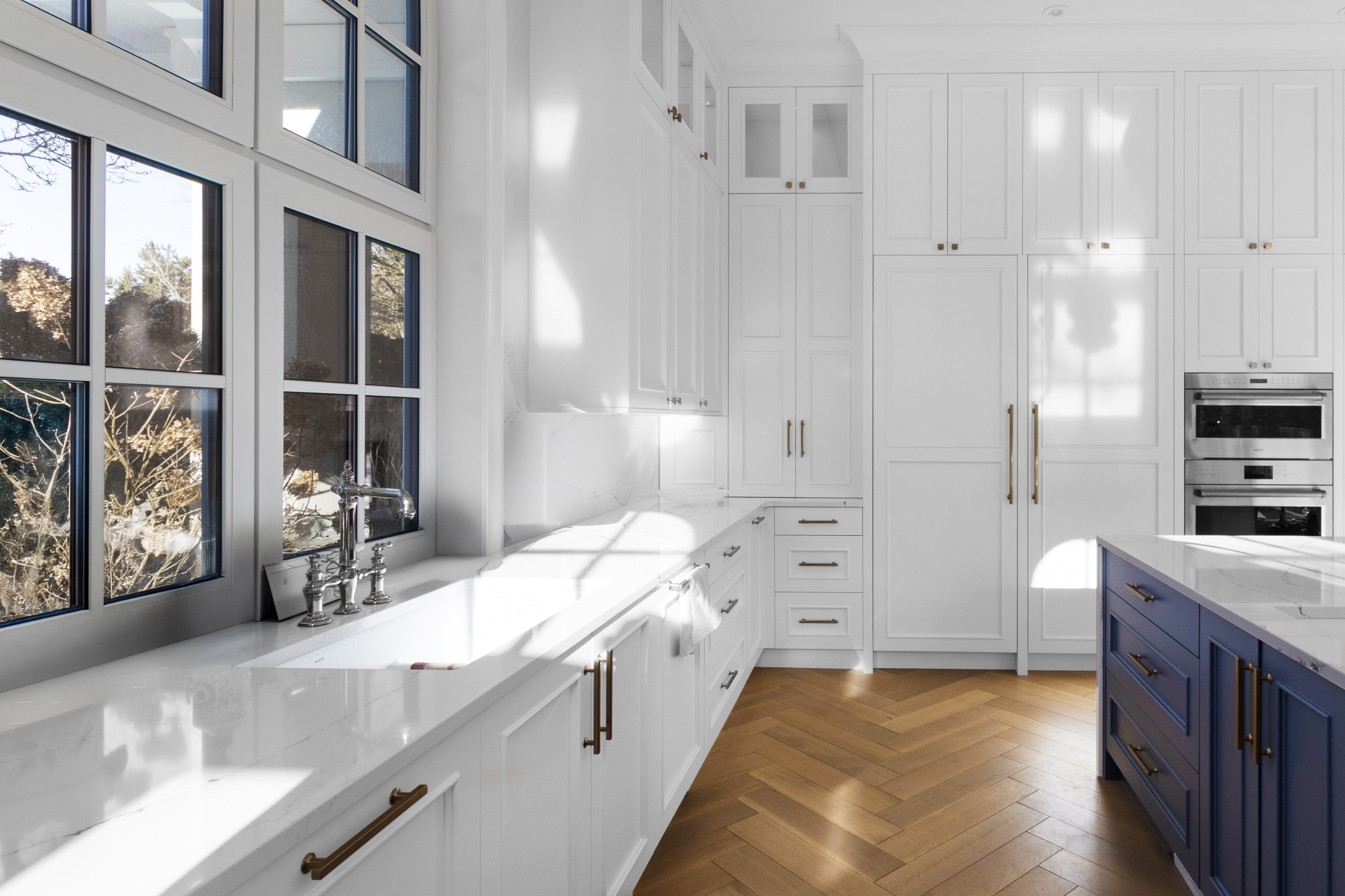 Sunlit 17th kitchen with blue island and integrated lighting